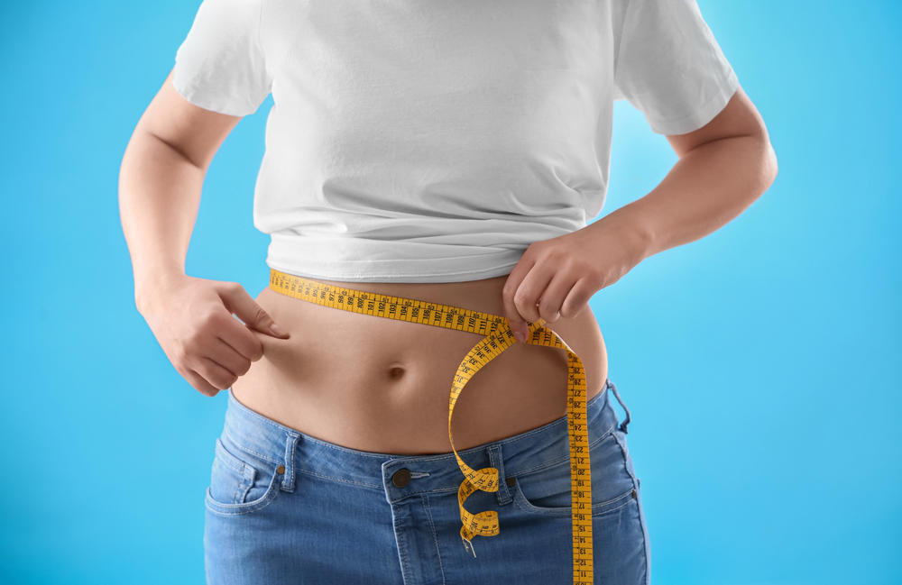 woman holding measuring tape around waist