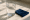 glass of fresh water on a table beside a folded navy napkin.